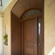 Exterior view of front door of this Regency-styled arch, door, window, wood, wood stain, brown