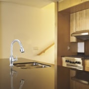 View of a kitchen which features a stainless bathroom, ceiling, countertop, floor, interior design, kitchen, light, light fixture, lighting, product design, room, sink, tap, under cabinet lighting, wall, brown, orange