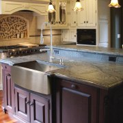 View of a kitchen which features a stainless cabinetry, countertop, cuisine classique, flooring, hardwood, interior design, kitchen, room, sink, under cabinet lighting, wood stain, black, gray