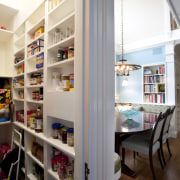 View of kitchen with dark turquoise island, colorful bookcase, interior design, pantry, shelf, shelving, white