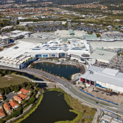 Exterior view of the Robina Town Centre where aerial photography, bird's eye view, city, metropolitan area, photography, real estate, residential area, suburb, urban area, urban design, water, waterway, gray, brown