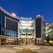 Exterior view of the Robina Town Centre where architecture, building, city, commercial building, condominium, convention center, corporate headquarters, headquarters, hotel, metropolis, metropolitan area, mixed use, plaza, real estate, shopping mall, sky, blue