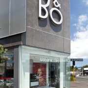 Exterior view of the Bang &amp; Olufsen shop. architecture, building, commercial building, corporate headquarters, facade, gray