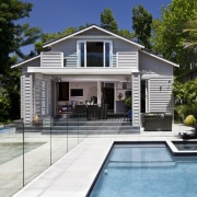 View of outdoor entertainment area, with pool, spa, architecture, cottage, estate, facade, home, house, property, real estate, swimming pool, villa, white