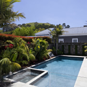 View of outdoor entertainment area, with pool, spa, architecture, arecales, backyard, estate, home, house, landscaping, leisure, palm tree, plant, property, real estate, residential area, resort, sky, swimming pool, tree, vacation, villa, water, teal