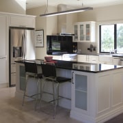 View of a kitchen designed and manufactured by cabinetry, countertop, cuisine classique, desk, floor, furniture, kitchen, room, gray