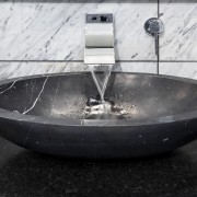 View of bedroom and bathroom with grey, black plumbing fixture, sink, water, black, white