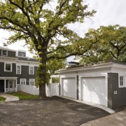 View of a multi-storey grey house with swimming architecture, building, cottage, facade, home, house, neighbourhood, plant, property, real estate, residential area, tree, brown, gray