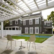 View of a multi-storey grey house with swimming backyard, courtyard, daylighting, estate, furniture, house, outdoor furniture, patio, real estate, table, white