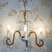 View of bathroom with floral wallpaper and dark-toned ceiling, centrepiece, chandelier, decor, light fixture, lighting, lighting accessory, gray