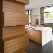 View of sculptural bank of wooden cabinetry, reflecting cabinetry, countertop, floor, flooring, furniture, hardwood, interior design, kitchen, laminate flooring, plywood, wall, wood, wood flooring, wood stain, brown