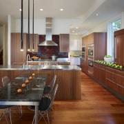 View of a kitchen which combines commerical touches cabinetry, countertop, dining room, flooring, hardwood, interior design, kitchen, real estate, room, wood flooring, brown, gray