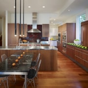 View of a kitchen which combines commerical touches cabinetry, countertop, dining room, flooring, hardwood, interior design, kitchen, real estate, room, wood flooring, brown, gray
