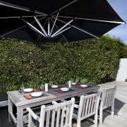 The rear yard of this home has been house, lighting, property, real estate, roof, umbrella, black