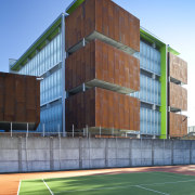 View of the Mt Eden Corrections Facility. - architecture, building, commercial building, corporate headquarters, elevation, facade, grass, headquarters, house, line, net, real estate, residential area, sky, sport venue, structure, teal