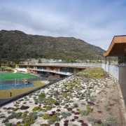 View of green roof at Remarkables Primary School. cloud, house, landscape, leisure, mountain, plant, real estate, reflection, sky, tree, water, teal, gray
