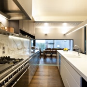 Stainless steel appliances. Minimalistic design. Indoor- outdoor flow. countertop, interior design, kitchen, white, orange