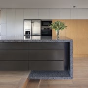 This house was designed by Andy MacDonald with cabinetry, countertop, floor, flooring, furniture, hardwood, interior design, kitchen, table, wood, wood flooring, gray, black