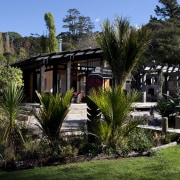 The timber for this house is treated with cottage, estate, grass, home, house, landscape, plant, real estate, tree, villa, black, brown