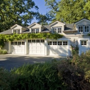 View of home with three garages. - View backyard, cottage, estate, facade, farmhouse, home, house, landscape, landscaping, mansion, neighbourhood, outdoor structure, property, real estate, residential area, siding, suburb, tree, yard, brown, black