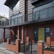 This house was designed by Gina Jones of apartment, balcony, building, condominium, elevation, facade, home, house, neighbourhood, property, real estate, residential area, siding, window, gray, black