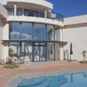 These windows were created with Glasshape's new curved apartment, building, condominium, estate, facade, home, hotel, house, property, real estate, resort, sky, swimming pool, villa, gray, teal