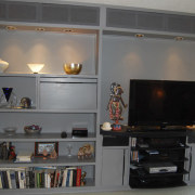 This home was remodeled by Forma Inc. A bookcase, furniture, home, interior design, living room, room, shelf, shelving, gray, black