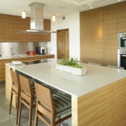 Architectural designer Mark Williams specified sleek Bulthaup walnut cabinetry, countertop, cuisine classique, floor, flooring, hardwood, interior design, kitchen, real estate, room, wood flooring, brown, orange