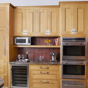 This kitchen was designed by Robert Schwartz of cabinetry, countertop, cuisine classique, cupboard, flooring, furniture, hardwood, home appliance, kitchen, room, wood, wood stain, orange