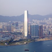 Here is a view of the ICC (International aerial photography, bird's eye view, building, city, cityscape, daytime, downtown, fixed link, landmark, metropolis, metropolitan area, sea, sky, skyline, skyscraper, tower, tower block, urban area, water, gray, blue