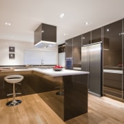 View of kitchen. Warm chocolare toens contrast with cabinetry, ceiling, countertop, floor, flooring, hardwood, interior design, kitchen, laminate flooring, room, wood, wood flooring, gray, brown