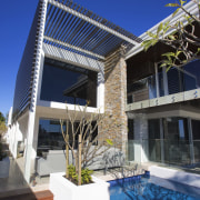 This home was designed by Jason Saunders of apartment, architecture, building, condominium, facade, home, house, outdoor structure, property, real estate, residential area, roof, swimming pool, blue