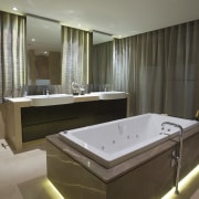 Bathroom with beige bathtub surround and grey curtains. bathroom, interior design, room, suite, brown, gray