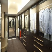 View of contempoary walk in wardrobe with dark boutique, furniture, interior design, lobby, black