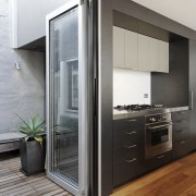 View of dark toned kitchen drawers and wooden door, home appliance, interior design, gray