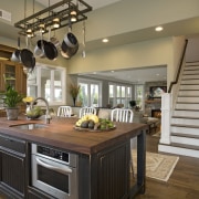 View of kitchen with wooden flooring, hanging pots cabinetry, countertop, cuisine classique, flooring, interior design, kitchen, brown, gray