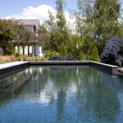 View of pool and landscaping. - View of estate, home, house, leisure, plant, property, real estate, reflecting pool, reflection, swimming pool, tree, water, teal