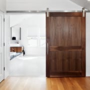 View of entrance to bathroom with wooden sliding cabinetry, door, floor, hardwood, interior design, room, wood, white