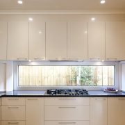 View of contemporary kitchen with white cabinetry and cabinetry, ceiling, countertop, cuisine classique, interior design, kitchen, property, real estate, room, under cabinet lighting, window, gray, orange