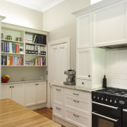 View of contemporary kitchen with wooden flooring and cabinetry, countertop, cuisine classique, floor, flooring, hardwood, home appliance, interior design, kitchen, laminate flooring, room, wood flooring, white