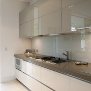 View of kitchen with light toned and grey cabinetry, countertop, glass, interior design, kitchen, property, gray