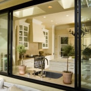 View through window to neutral toned kitchen. - ceiling, home, interior design, living room, window, orange, brown