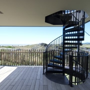 View of spiral staircase and deck of contemporary apartment, architecture, balcony, condominium, handrail, home, house, property, real estate, sky, gray