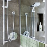 Walnut cabinetry lines the entry to this glass bathroom, plumbing fixture, shower, tap, gray