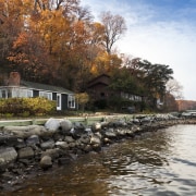 Riverside house surrounded by trees. - Riverside house autumn, bank, cottage, home, house, lake, leaf, plant, real estate, reflection, river, sky, tree, water, waterway, black, white