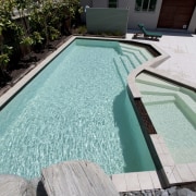 View of contemporary house with pool. - View backyard, leisure, pool, property, swimming pool, water, teal, black, gray