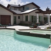 View of contemporary house with pool. - View backyard, estate, home, house, leisure, property, real estate, residential area, resort, swimming pool, villa, water, teal, black