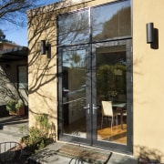 Outdoor patio area with furniture. - Outdoor patio architecture, cottage, courtyard, door, facade, home, house, outdoor structure, real estate, shed, siding, window, black