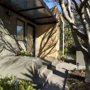 Entrance leading up to house with landscaping. - architecture, backyard, cottage, facade, home, house, outdoor structure, plant, property, real estate, residential area, roof, siding, tree, walkway, window, yard, black