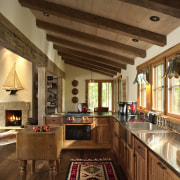 Kitchen with exposed ceiling beams and wooden cabinetry. beam, ceiling, countertop, estate, interior design, kitchen, living room, real estate, brown